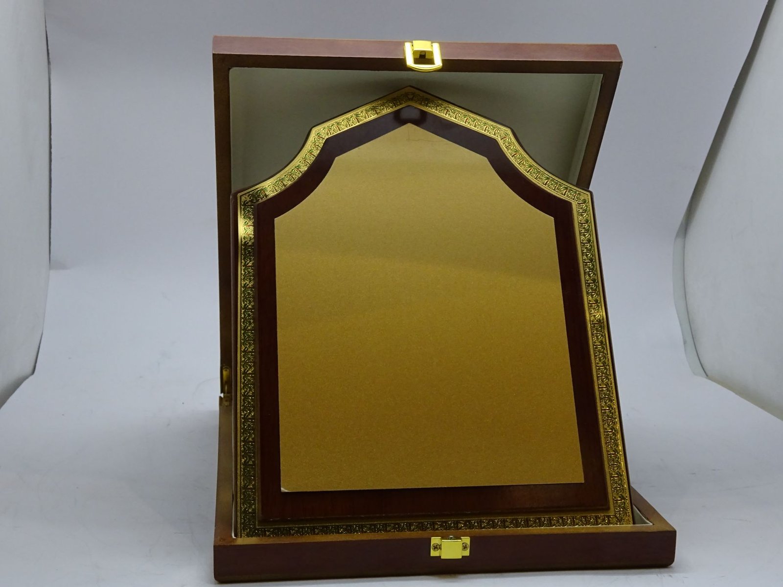 درع معدني ذهبي على خشب