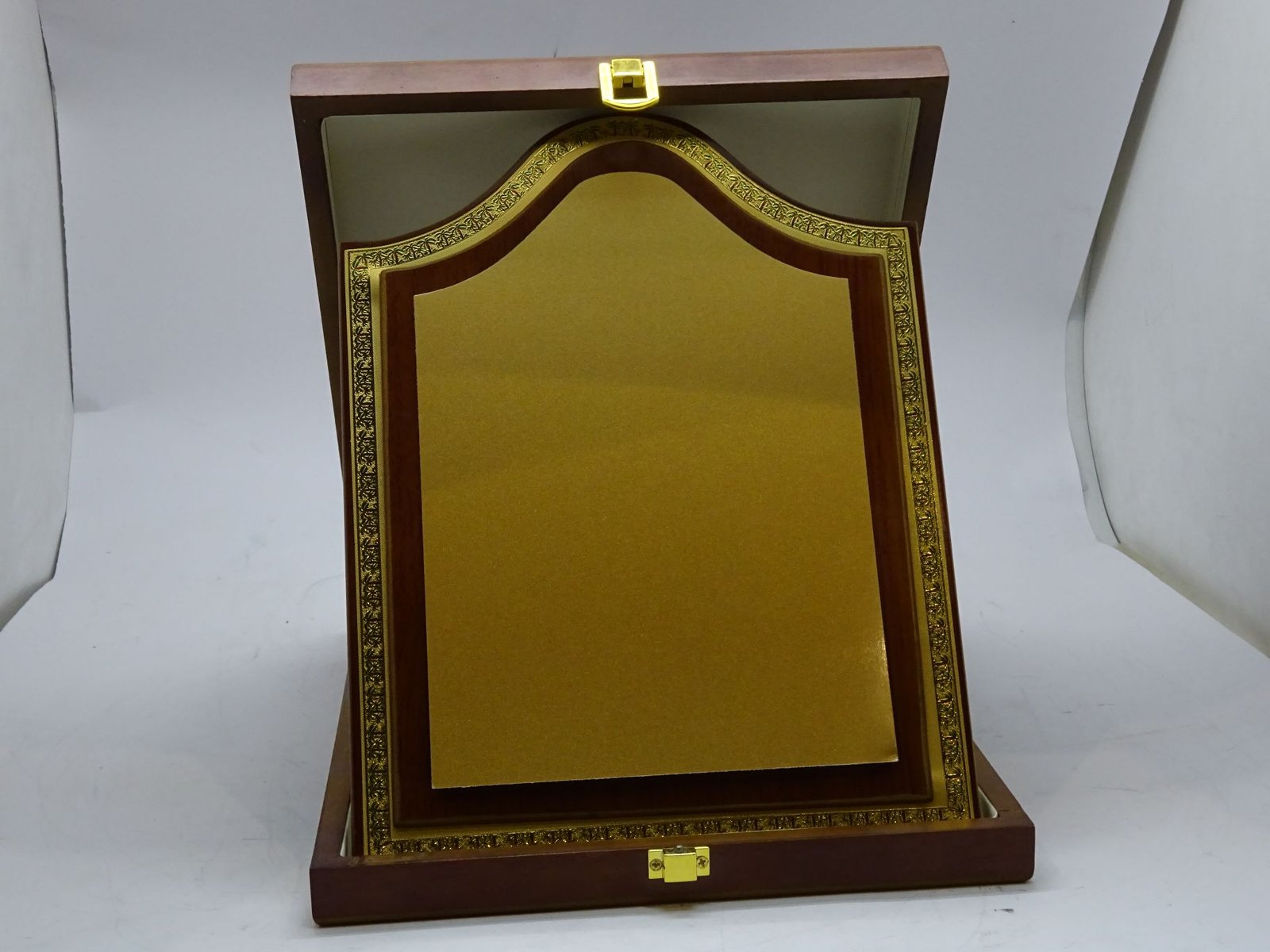 درع معدني ذهبي على خشب